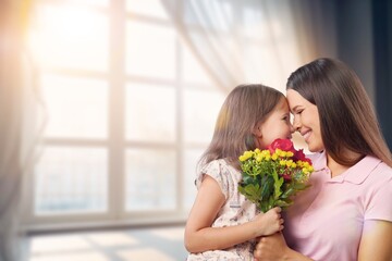 Happy Child daughter giving bouquet of flowers to mother