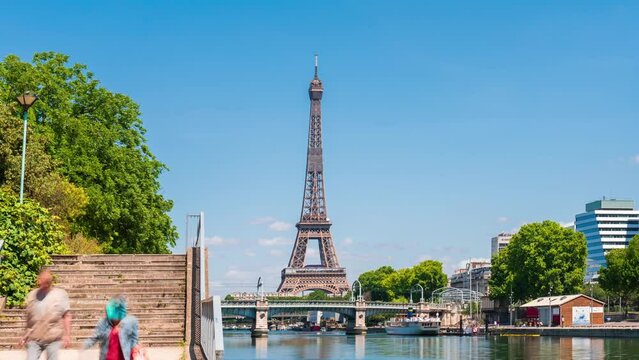 A timelapse of the Eiffel Tower along the river Seine with flyboats passing by with motion blur.Sunny but cloudy spring summer day paris city famous riverside bay tower view bridge timelapse panorama