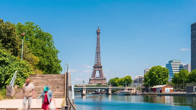 A timelapse of the Eiffel Tower along the river Seine with flyboats passing by with motion blur.Sunny but cloudy spring summer day paris city famous riverside bay tower view bridge timelapse panorama