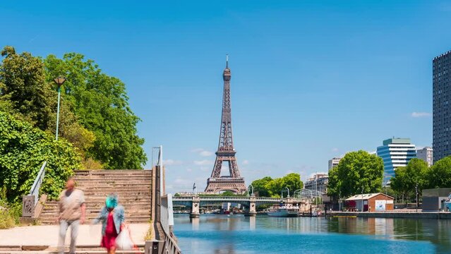 A timelapse of the Eiffel Tower along the river Seine with flyboats passing by with motion blur.Sunny but cloudy spring summer day paris city famous riverside bay tower view bridge timelapse panorama