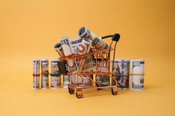 Shopping Cart Full of Cash Isolated on Yellow Background