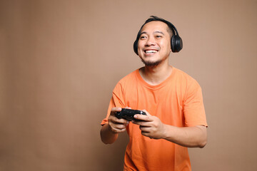 Asian gamer man playing video games using joystick with excited face