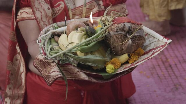 indian women worshiping hindu almighty sun god with holy offerings at chhath festival