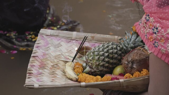 indian devotee worshiping hindu almighty sun god with holy coconut offerings at chhath festival