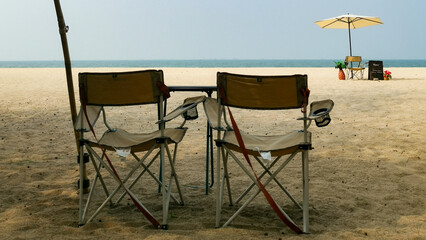 Two chairs set on the seashore for a peaceful view ahead.
