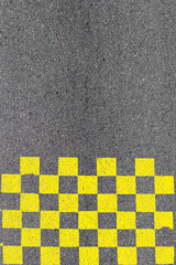 Damier jaune sur asphalte 