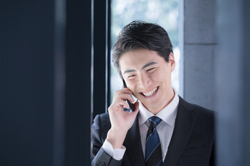 Fresh Exec male businessman in a suit making a phone call (call) with a smile by the window Nice...