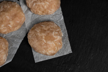 Frozen chicken meat cutlets on dark black background, semi-finished, ready for cooking. Convenience and homemade frozen healthy meals.