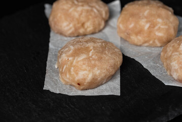 Frozen chicken meat cutlets on dark black background, semi-finished, ready for cooking. Convenience and homemade frozen healthy meals.