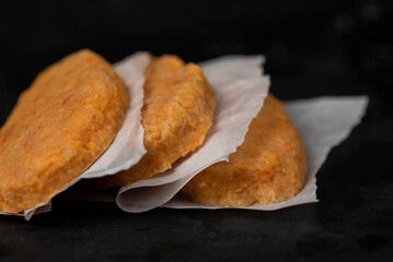 Frozen fish cutlets on dark black background, semi-finished, ready for cooking. Convenience and homemade frozen healthy meals.