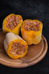 Frozen stuffed peppers filled with meat and rice, on dark black background, semi-finished, ready for cooking. Convenience and homemade frozen healthy meals.