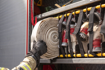 Firefighters at work pulling the hose out of the fire truck
