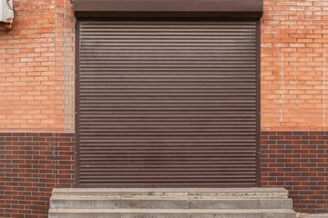 Closed brown roller shutter  door front view.