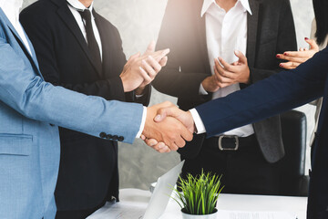 Two businessmen handshaking in meeting after final project agreement deal done