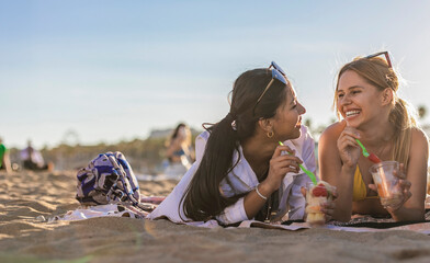 Friends Laughing and Enjoying Fruit on the Beach