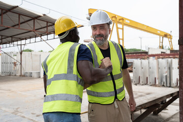 Portrait African American engineer man hand shake with caucasian engineer man at precast cement...