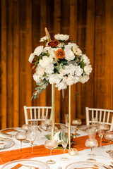Tall wedding centerpiece table with white and orange flowers