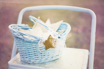 Blue basket filled with glittery stars, placed on a light blue s