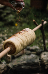 Making Stock bread over fire, sprinkling seasoning onto it
