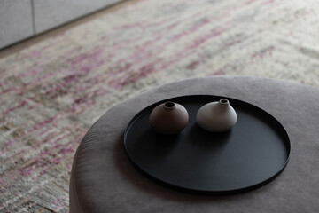Minimalist vases on a black tray in a serene, modern setting