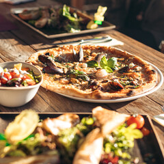 Sunlit Pizza with  fresh seafood on a rustic wood table