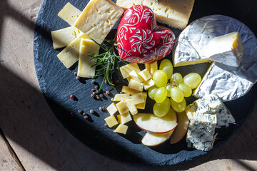 Cheese platter with grapes, apple slices, and a decorative heart