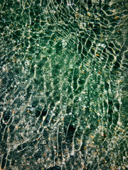 Water rippling with pebbles and sand