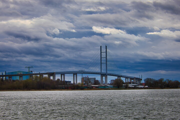 Obraz premium Moderne Rügenbrücke über den Strelasund bei Stralsund unter dramatischem Wolkenhimmel, Verbindung zur Insel Rügen, Mecklenburg-Vorpommern
