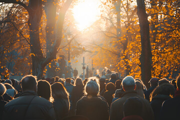 A solemn gathering of people at a funeral service in a cemetery during autumn, with sunlight filtering through trees. AI