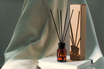 Liquid home perfume in glass diffuser with sticks on chair