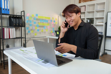 Young Asian businesspeople use smartphones to communicate online. Office worker making financial...