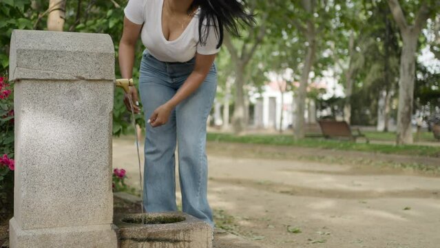 Voluptuous curvy woman drinking water from a fountain.MOV