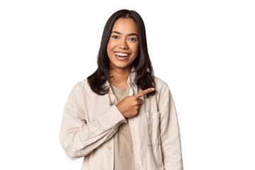 Portrait of a young Filipino woman smiling and pointing aside, showing something at blank space.