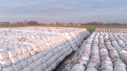 Rubbish dump with bundle pack of plastic garbage ready to send for recycling. Green country side on the background