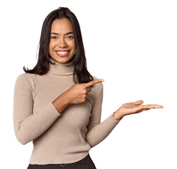 Young filipino woman excited holding a copy space on palm.