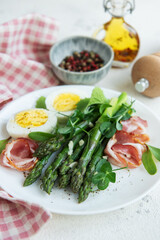 Fresh Asparagus and Prosciutto Salad Served With Boiled Eggs and Microgreens