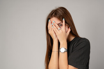 Fototapeta premium Young Woman Covering Face With Hands in Studio