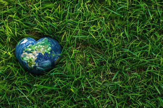 Save earth concept . earth in heart shape on the grass field