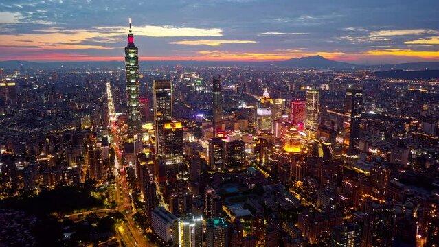 Aerial hyperlapse at sunset above Downtown Taipei, the vibrant capital of Taiwan, with 101 Tower standing out amid skyscrapers in XinYi Commercial District and city lights dazzling under twilight sky
