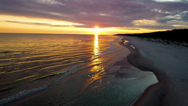 aerial view with sunrise over the baltic sea with wave on the sand beach,4k poland