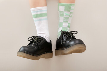 Kid wears different pair of socks. Child foots in mismatched socks, studio photography. Down...