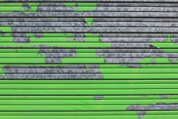 Peeled green metallic alloy garage door shutter. Full frame. background and texture 
