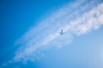 Large airplane passing above clouds.
