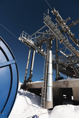 A cable car station high in the mountains under construction. Snowy mountain landscape and...