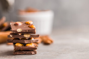 Broken chocolate bar with almonds on kitchen table.