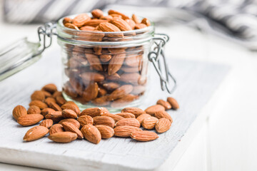 Peeled almond nuts in jar on kitchen table.