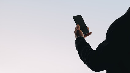 Young man reading and texting on his smartphone, connected to social media