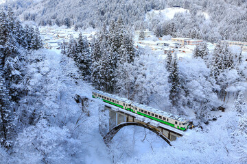 雪の新宮下橋を渡る只見線気動車