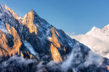 Mountains with sunlit peaks in clouds in Nepal