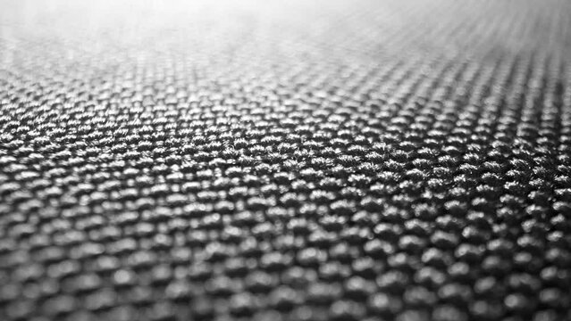 Explore the depths of the black polyester's weave, radiant under light, with a smooth, glossy sheen. Its tightly interlocked threads form a durable and aesthetically pleasing design.
